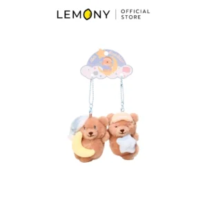 พวงกุญแจตุ๊กตาหมีสีน้ำตาลแพ็กคู่ในธีม Sweet Dreams ตัวซ้ายสวมหมวกนอนสีฟ้าถือพระจันทร์เสี้ยวสีเหลือง ตัวขวาสวมผ้าปิดตาถือดาวสีฟ้าอ่อน ทั้งคู่ห้อยอยู่กับป้ายกระดาษรูปก้อนเมฆสีพาสเทล