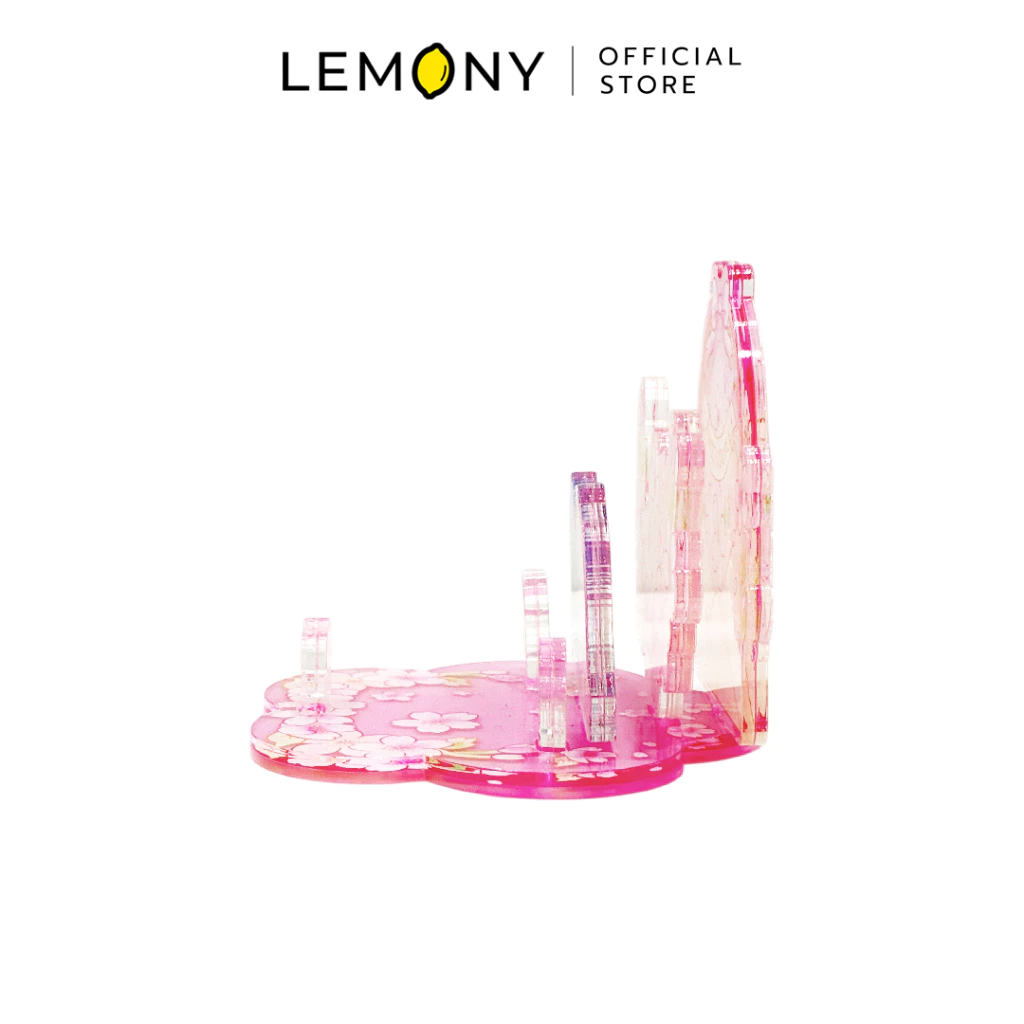 ภาพถ่ายมุมข้างของ LEMONY แท่นวางโทรศัพท์มือถืออะคริลิก เผยให้เห็นโครงสร้างการต่อประกอบแผ่นอะคริลิกใสเป็นชั้นเลเยอร์สามมิติบนแผ่นฐานสีชมพูโปร่งแสง โชว์ความหนาของตัววัสดุและร่องล็อกสำหรับรองรับการตั้งวางโทรศัพท์มือถือ