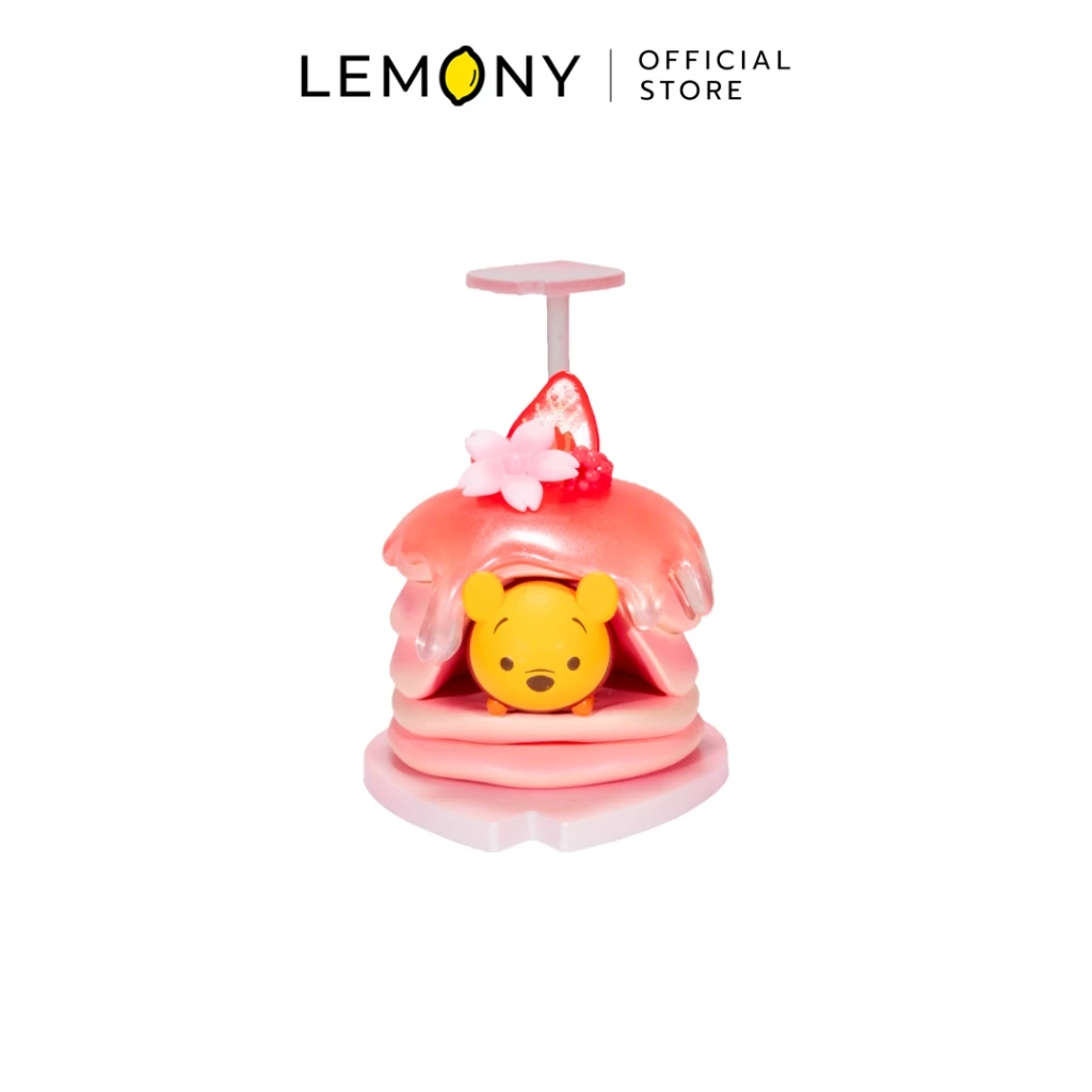 LEMONY กล่องสุ่มฟิกเกอร์ดิสนีย์ ธีมเค้กของหวาน ลาย หมีพูห์ (Winnie the Pooh) โมเดลหมีพูห์สีเหลืองนอนคว่ำสุดคิ้วท์อยู่ระหว่างชั้นแพนเค้กราดซอสแยมสตรอว์เบอร์รี่สีชมพูใสเยิ้ม ด้านบนประดับผลเบอร์รี่และดอกไม้ซากุระ