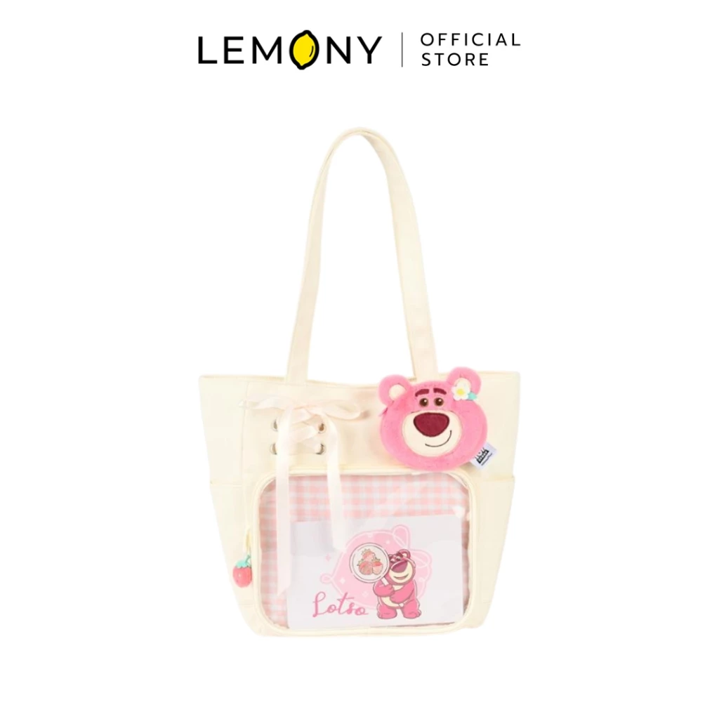 LEMONY กระเป๋าสะพายไหล่ดิสนีย์ ซีรีส์ Early Summer ลาย Lotso ตัวกระเป๋าผ้าสีครีมละมุน ช่องกระเป๋าด้านหน้าบุด้วยผ้าลายตารางสก็อตสีชมพูพาสเทลสลับขาว ประดับด้วยหน้าตุ๊กตาหมีล็อตโซ่สีชมพูขนนุ่มนิ่มติดดอกไม้สีขาว และดีเทลเชือกร้อยโบว์สีครีมด้านข้างช่องกระเป๋า