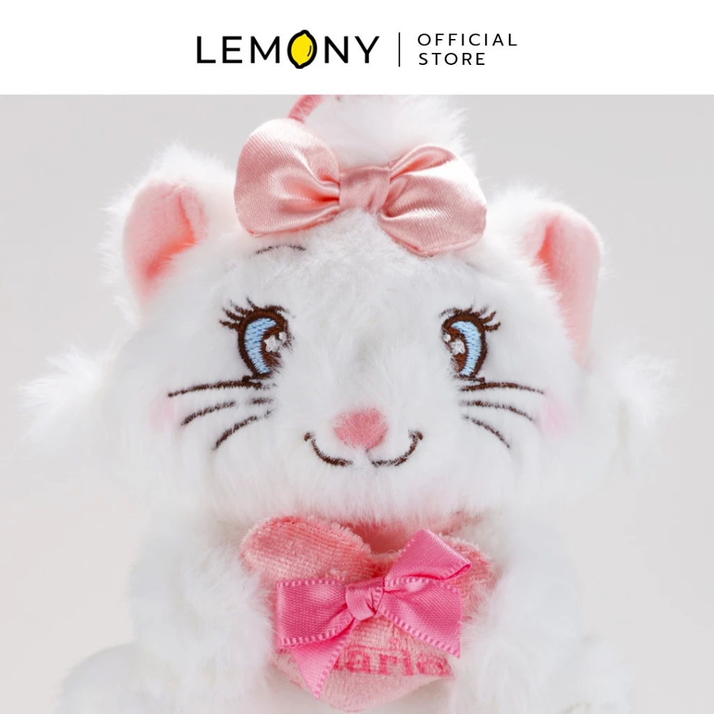 ภาพหลักฉากหลังขาวแสดงรายการสินค้า LEMONY พวงกุญแจตุ๊กตามารี แมวเหมียวพเนจร ขนาด 11 ซม. ลิขสิทธิ์แท้ จัดวางพวงกุญแจตุ๊กตาผ้าขนฟูสีขาวหน้าตรง เผยรายละเอียดงานปักใบหน้า ดวงตากลมโต ขนตางอน และแก้มชมพูระเรื่อซิกเนเจอร์ของน้องแมวมารี โดดเด่นด้วยงานตกแต่งโบผ้าสีชมพูสดใสสะดุดตาที่คอและบนศีรษะ ด้านบนเชื่อมต่อกับสายห้อยพวงกุญแจลูกปัดพลาสติกสีชมพูพาสเทลหวานละมุนสไตล์มินิมอลเกาหลี ด้านบนระบุโลโก้แบรนด์ออฟฟิเชียลชัดเจน