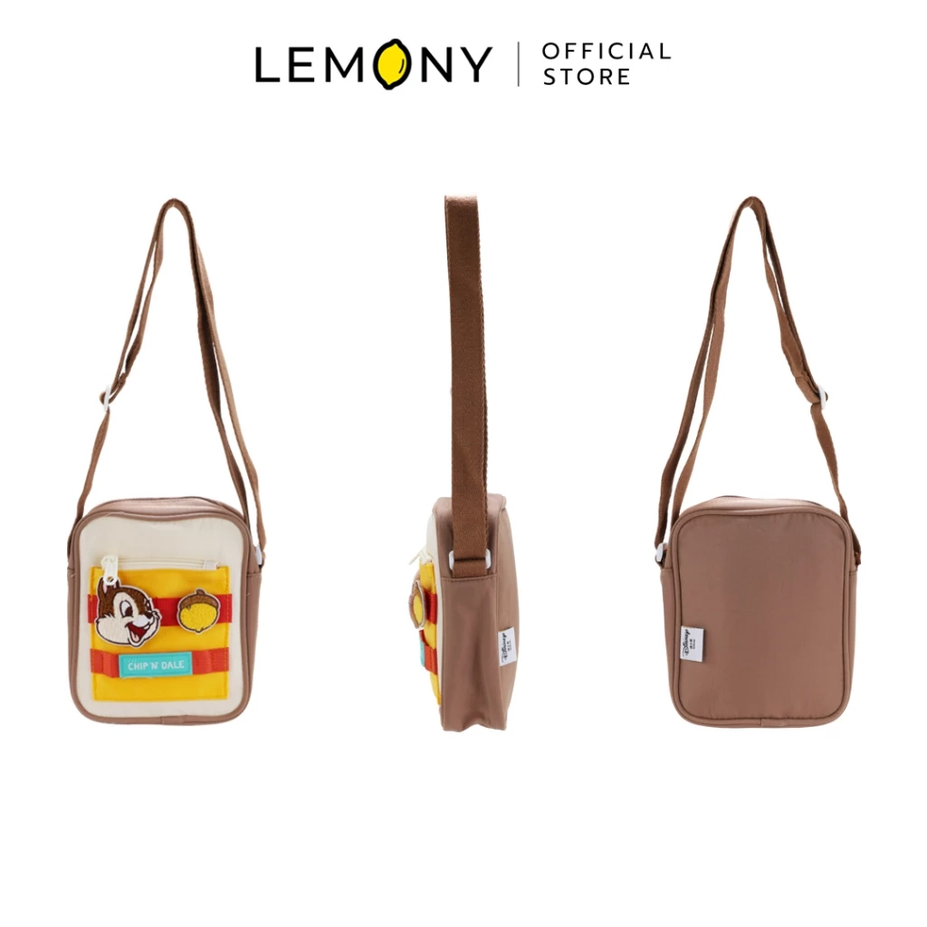 ภาพสินค้าฉากหลังขาวแสดงมุมมอง 3 ด้านของกระเป๋าสะพายข้างดิสนีย์ ซีรีส์ Candy ลายชิป (Chip) ตัวกระเป๋าผ้าสีน้ำตาลครีม ด้านซ้ายโชว์มุมหน้าตรงปักลายชิปคู่กับลูกกะาลัดบนช่องซิปหน้าสีเหลืองสลับส้ม มีป้ายคำว่า CHIP 'n DALE มุมกลางโชว์ด้านข้างหนา 6 ซม. และด้านขวาโชว์มุมหลังเรียบ มีสายสะพายยาวสีน้ำตาลเข้าเซ็ต ด้านบนระบุโลโก้แบรนด์ LEMONY Official Store