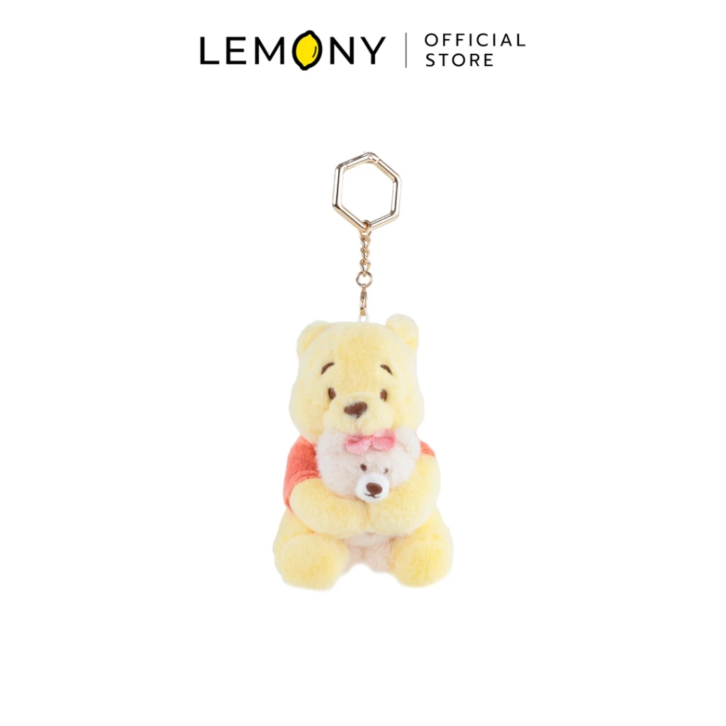 ภาพกราฟิกหน้าตรงเต็มตัวฉากหลังขาว LEMONY พวงกุญแจตุ๊กตาหมีพูห์ ซีรีส์ Tasty Hug ขนาด 7x8x10 ซม. ดีไซน์หมีพูห์ขนนุ่มสีเหลืองสวมเสื้อสีส้มกอดหมีจิ๋วสีขาวติดโบว์ชมพู มาพร้อมห่วงคล้องโลหะสีทองทรงหกเหลี่ยมด้านบน ด้านบนมีโลโก้ Official Store ชัดเจน