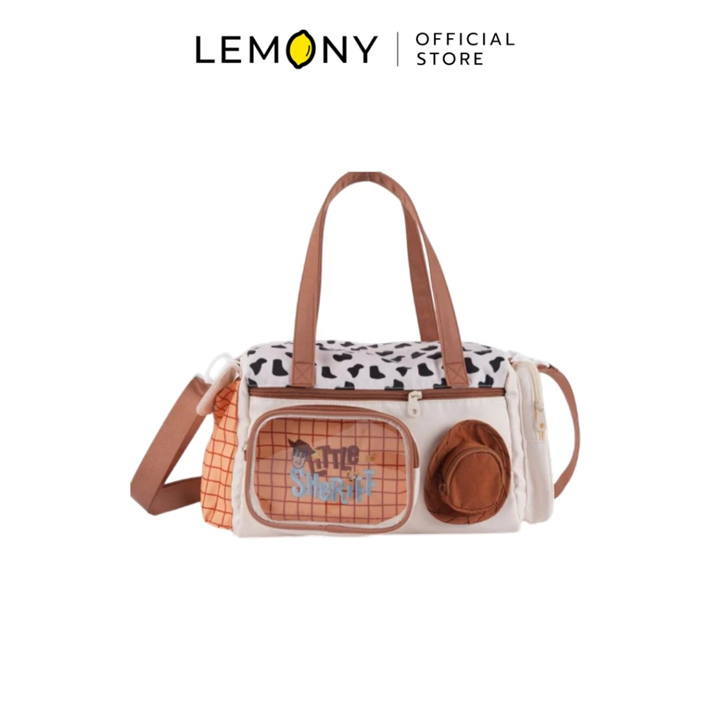 ภาพหลักหน้าตรงเต็มใบของผลิตภัณฑ์ LEMONY กระเป๋าสะพายไหล่ Woody ทอยสตอรี่ ซีรีส์ Cheese Candy ขนาด 32x16x21.5 ซม. บนฉากหลังสีขาวสะอาดตา โดดเด่นด้วยดีไซน์กระเป๋าผ้าสีครีมที่ผสมผสานลวดลายประจำตัวของนายอำเภอวู้ดดี้อย่างเป็นเอกลักษณ์ ทั้งลายวัวบริเวณฝากระเป๋าด้านบน ลายตารางสีส้มอิฐด้านข้าง มาพร้อมหูหิ้วคู่และสายสะพายไหล่สีน้ำตาล ด้านหน้าประดับกระเป๋าซิปโปร่งใสพิมพ์อักษร Little Sheriff คู่กับกระเป๋าใบจิ๋วทรงหมวกคาวบอยขนนุ่มสีน้ำตาล ลิขสิทธิ์แท้ ด้านบนแสดงโลโก้แบรนด์ LEMONY Official Store ชัดเจนพรีเมียม
