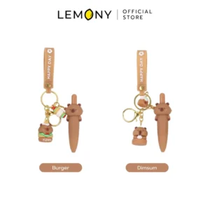 ภาพรวมตัวเลือกผลิตภัณฑ์ LEMONY พวงกุญแจปากกาเจลคาปิบาร่า หมึกน้ำเงิน 0.5 มม. จัดวางคู่กันหน้าตรงบนฉากหลังสีขาว มีป้ายแถบสีน้ำตาลกำกับชื่อลายชัดเจนใต้ภาพ ได้แก่ ลาย Burger และลาย Dimsum ด้านบนแสดงโลโก้ Official Store พรีเมียมชัดเจน