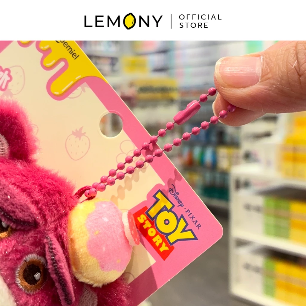 ภาพถ่ายซูมรายละเอียดของพวงกุญแจแม่เหล็ก LEMONY โชว์มือจับสายโซ่ไข่ปลาโลหะเคลือบสีชมพูเข้มที่ต่อเข้ากับตัวตุ๊กตาหมีล็อตโซ่ขนนุ่ม และป้ายกระดาษแพ็กเกจสีชมพูพิมพ์ตราโลโก้ Toy Story ลิขสิทธิ์แท้