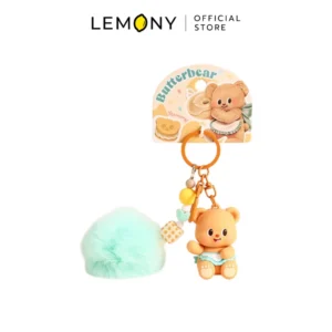 ภาพสินค้าหลักไดคัทฉากหลังขาว โฟกัสชิ้นงานพวงกุญแจหมีเนย ซีรีส์ Dessert Notes หน้าตรง โมเดลหมีเนย Butterbear นั่งอมยิ้มสวมผ้ากันเปื้อนขอบสีฟ้า พ่วงพู่ขนปุยปอมปอมสีเขียวมิ้นต์ สายลูกปัดตกแต่งพาสเทล พ่วงแผงการ์ดกระดาษแข็งสกรีนลาย Butterbear อบขนมปังน่ารัก ด้านบนสุดระบุตราสัญลักษณ์ร้านค้า LEMONY Official Store ชัดเจนครับ