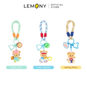 ภาพสินค้าหลักไดคัทฉากหลังขาว จัดวางองค์ประกอบพวงกุญแจหมีเนย ซีรีส์ Leisure Time Butter Bear Collection เรียงหน้าตรงแนวราบพร้อมกัน 3 ดีไซน์เพื่อเปรียบเทียบ ฝั่งซ้ายใต้ป้ายกำกับสีเขียวมิ้นต์พิมพ์ชื่อลาย Picnic Trip (หมีเนยชุดเขียวหมวกชมพูถือตะกร้า), ตรงกลางใต้ป้ายกำกับสีฟ้าพิมพ์ชื่อลาย Little Athlete (หมีเนยชุดกีฬาถือไม้เทนนิส) และฝั่งขวาใต้ป้ายกำกับสีเหลืองส้มพิมพ์ชื่อลาย Sailing Diary (หมีเนยชุดทหารเรือหมวกกะลาสี) ทุกชิ้นมาพร้อมสายเชือกถักสลับสีแมทช์เข้าชุดประณีตเรียบร้อยเนียนตลับ ด้านบนสุดระบุตราสัญลักษณ์ร้านค้า LEMONY Official Store ชัดเจนครับ